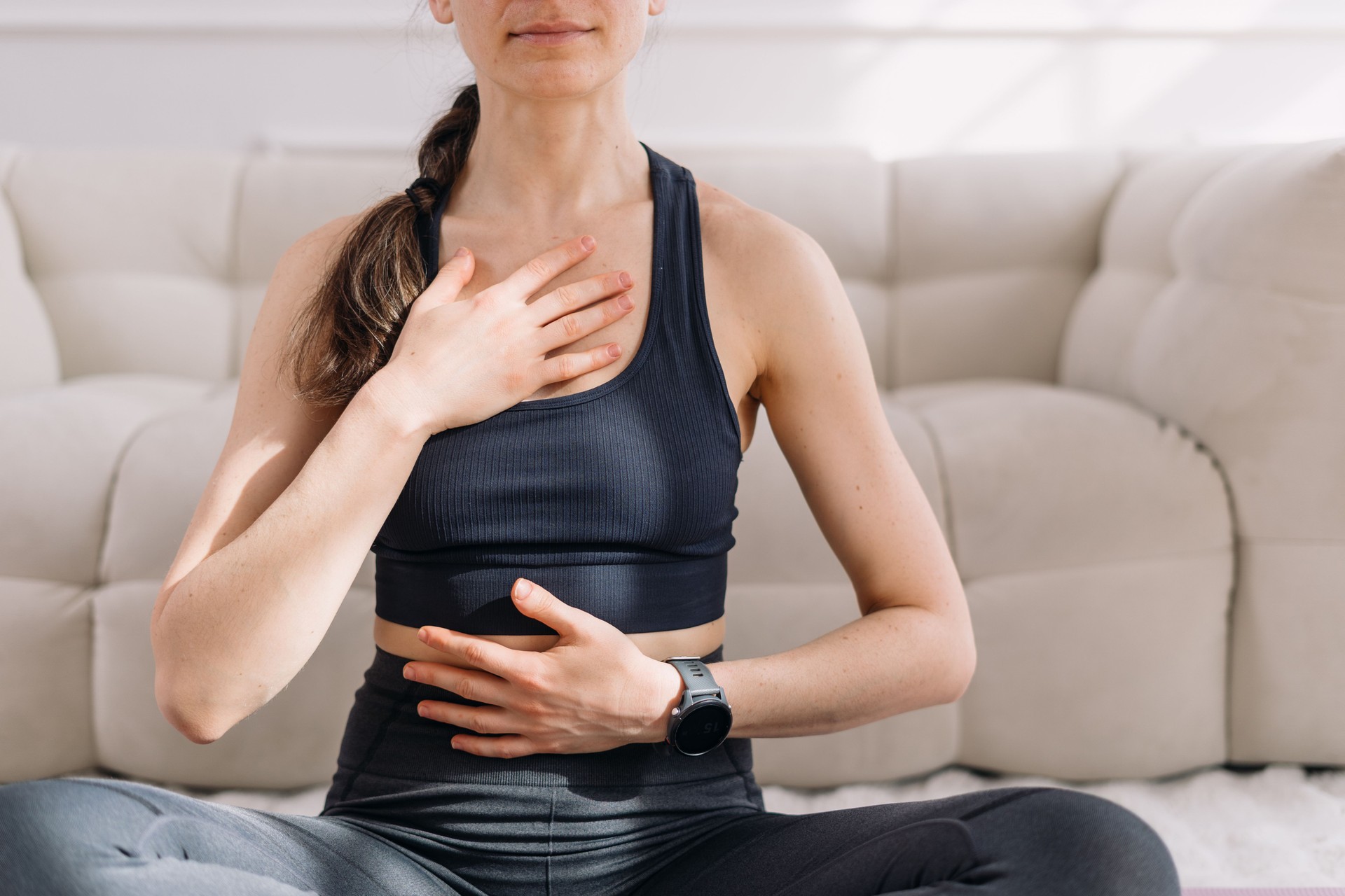 Fit woman engages in yoga breathing exercises at home for relaxation and wellness